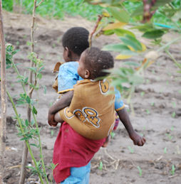 AIDS orphans, the older carrying the younger, in a village in Bangula, Malawi