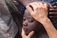 A nurse with the team examines and older orphan's eye infection.
