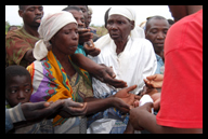 Desperate elderly village women line up for a handout of pain medication