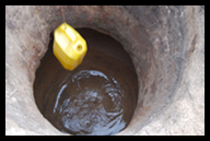 Water being retrieved through a shallow well, unpotable and deadly to most people, but necessary for sub-Saharan African people